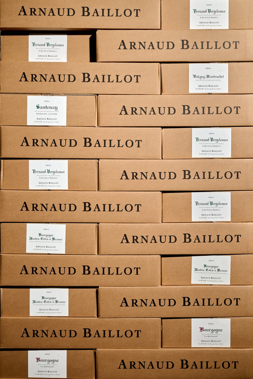 Stěna kartonů Arnaud Baillot s etiketami Pernand-Vergelesses a Bourgogne Hautes-Côtes de Beaune, ročník 2024.